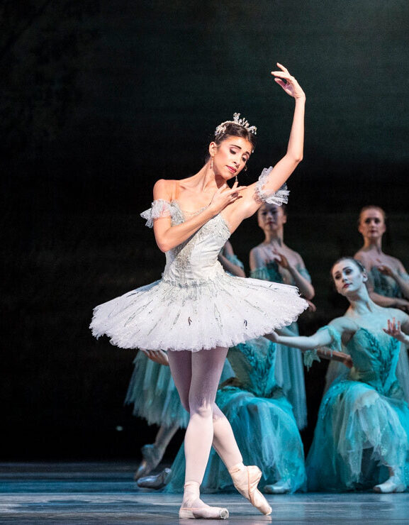Yasmine Naghdi as Aurora in a white tutu, on stage in The Sleeping Beauty